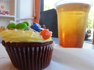 My red velvet cupcake with lemon frosting with Skittles, walnut and coconut flakes with a passion fruit/mango iced tea. (July 24, 2015)